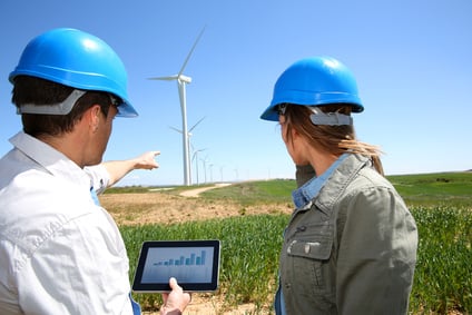 Engineers using tablet on wind turbine site